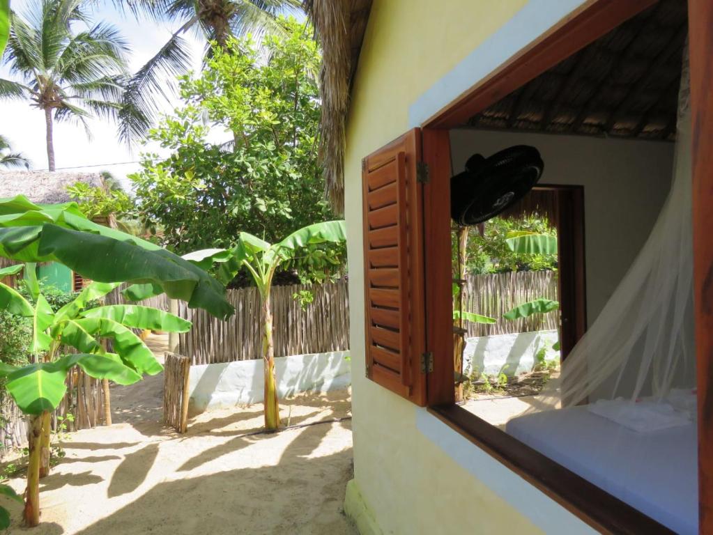 a room with a window with a fence and trees at Pitico - Pousada Icaraí Kite Village in Icaraí