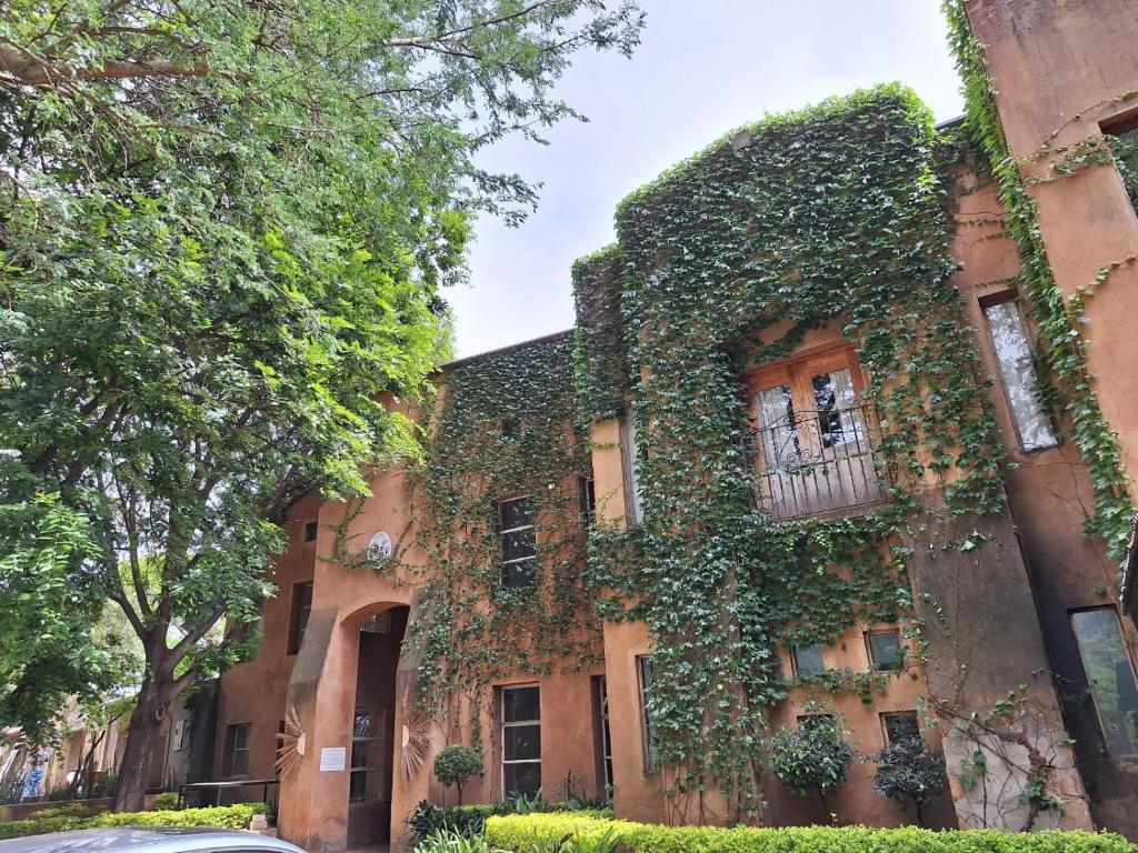 a building covered in ivy on a street at Bosheuvel Country Estate in Muldersdrift