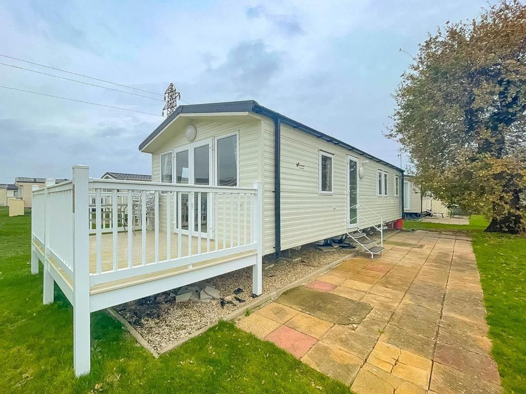 a large white house with a porch at Wonderful 8 Berth Caravan With Decking At Valley Farm, Essex Ref 46561v in Great Clacton