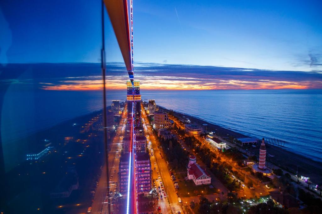 an aerial view of a city at night at Panorama Orbi Resort in Batumi