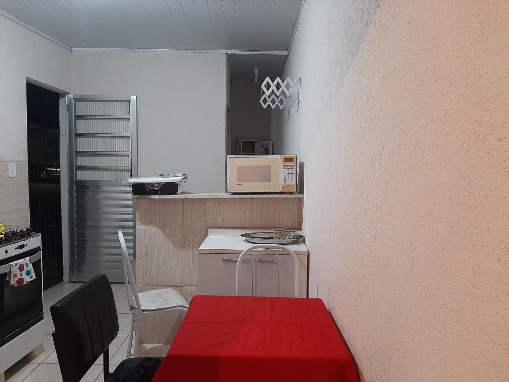 uma pequena cozinha com uma mesa e um micro-ondas em Casa compacta em São Caetano do Sul