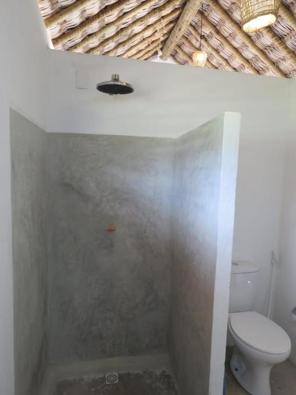 a bathroom with a toilet and a bath tub at Pitico - Pousada Icaraí Kite Village in Icaraí