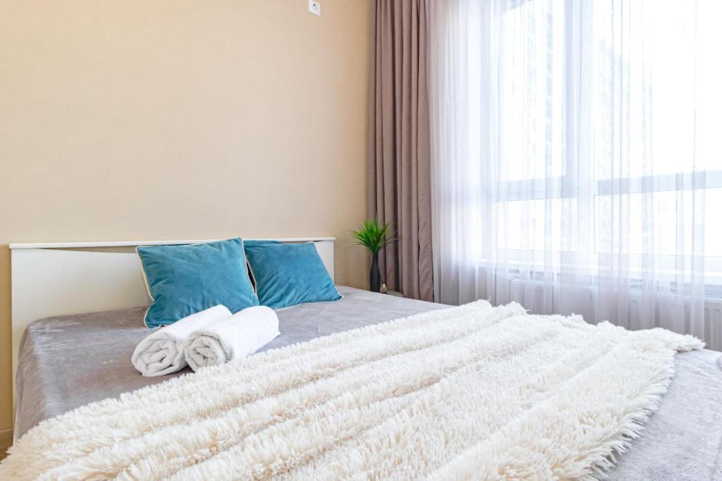 1 dormitorio con 1 cama con toallas y ventana en Хан Шатыр, en Taldykolʼ