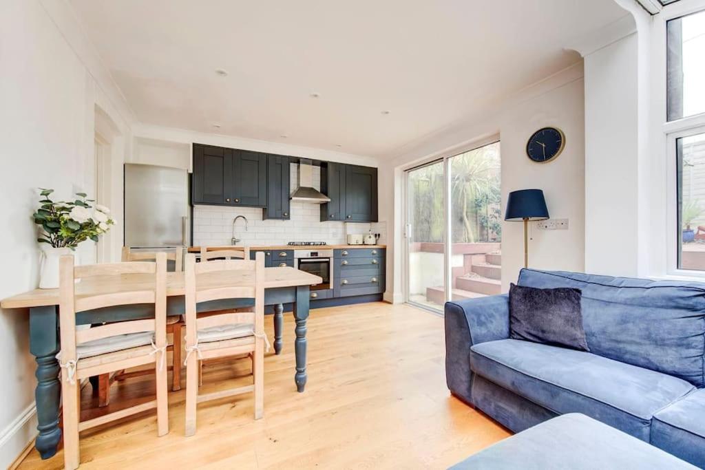 GuestReady - Superb haven near Hampstead Heath في لندن: غرفة معيشة مع طاولة وأريكة زرقاء
