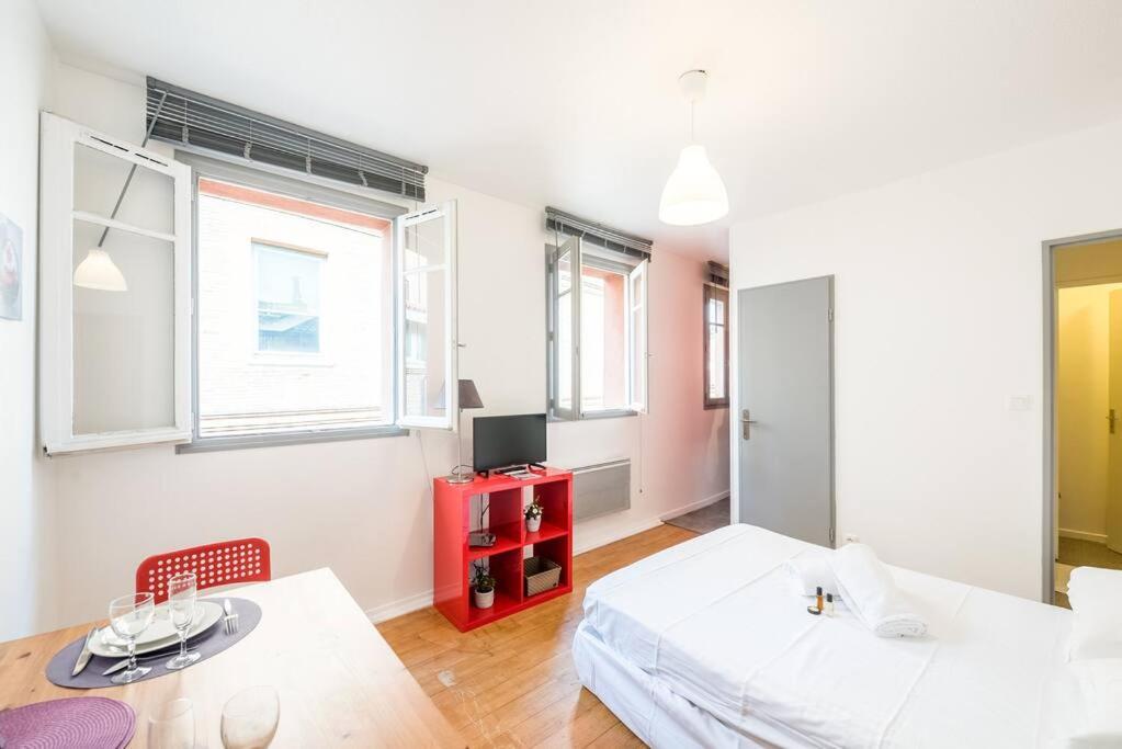 a bedroom with a bed and a table and a tv at Saint-Sernin - Centre-ville - Calme - WIFI fibre in Toulouse