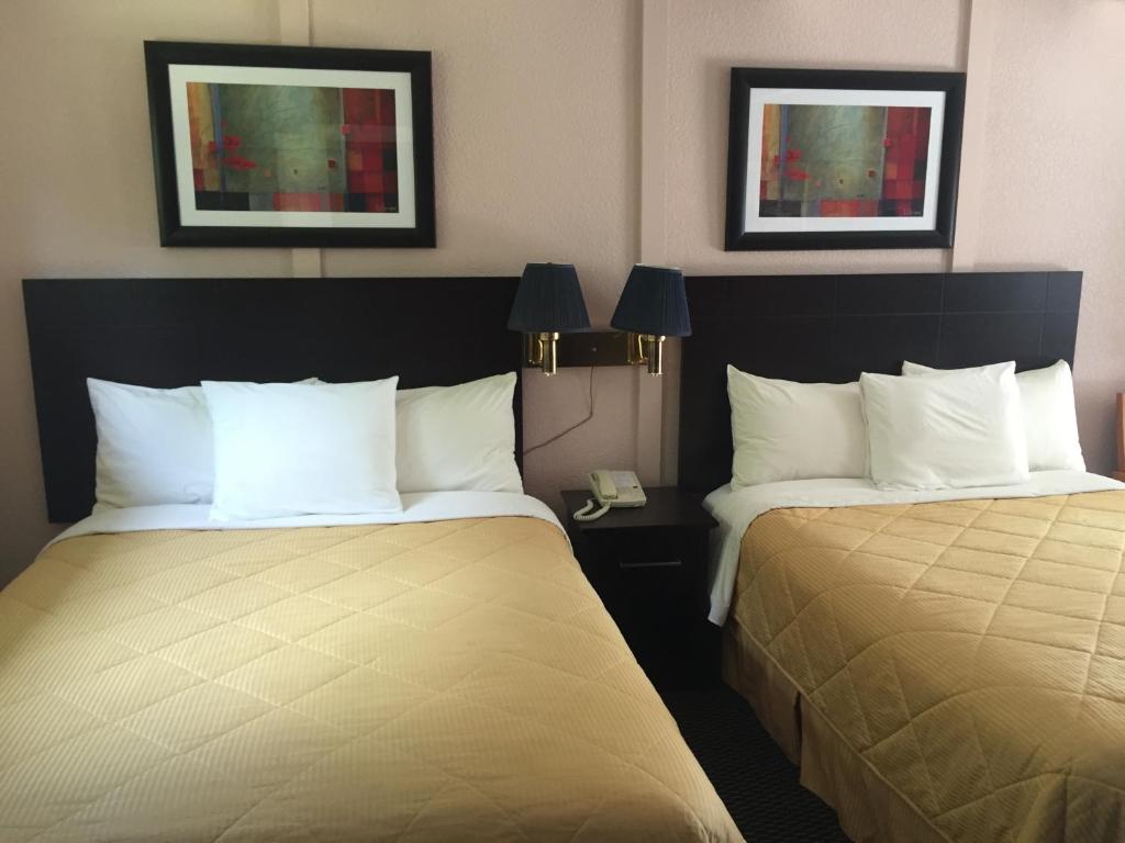 a hotel room with two beds and two lamps at Country Squire Motel in Arnprior
