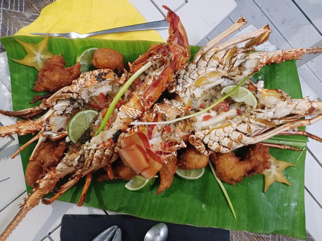 a plate of food with seafood on a banana leaf at La Rose du Bresil Marie-Galante in Capesterre