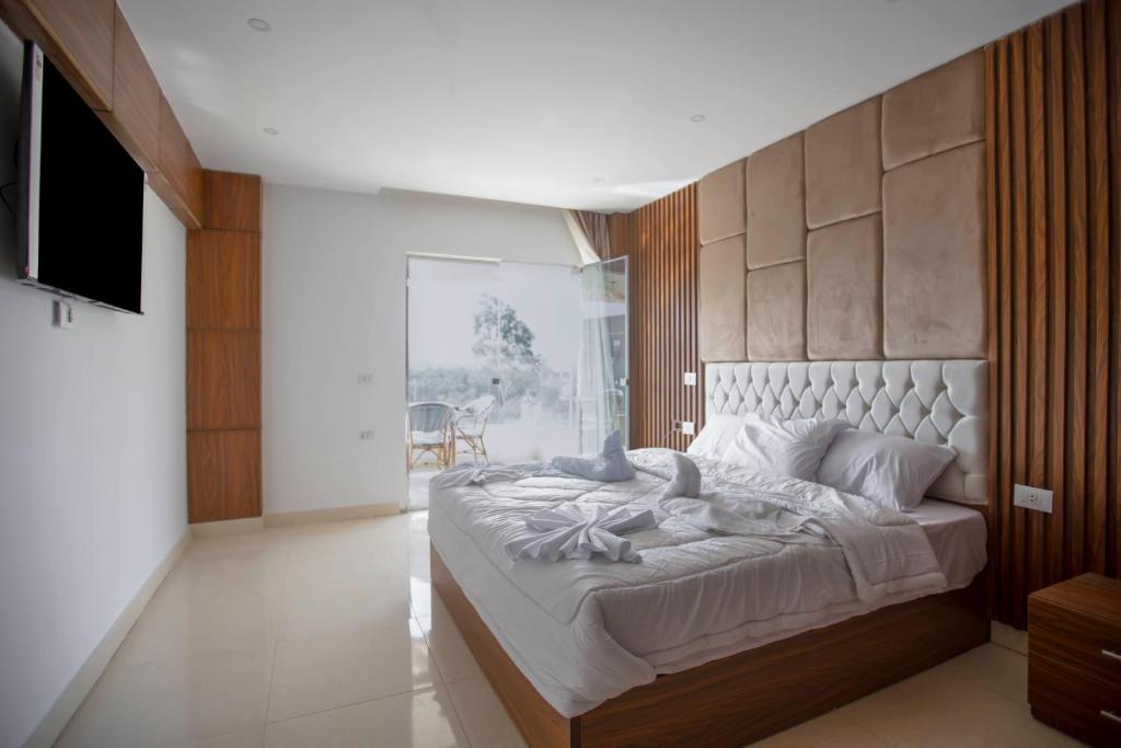 1 dormitorio con 1 cama grande y cabecero de madera en King Pyramids View Hotel en El Cairo