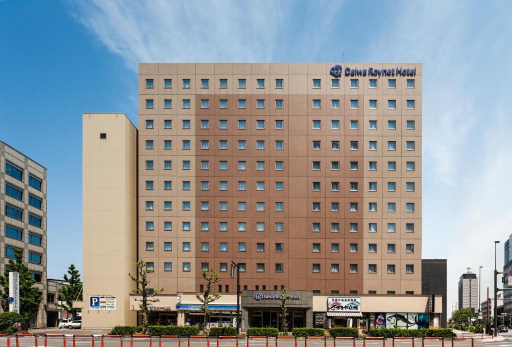 un edificio alto marrón con un letrero. en Daiwa Roynet Hotel Oita en Oita