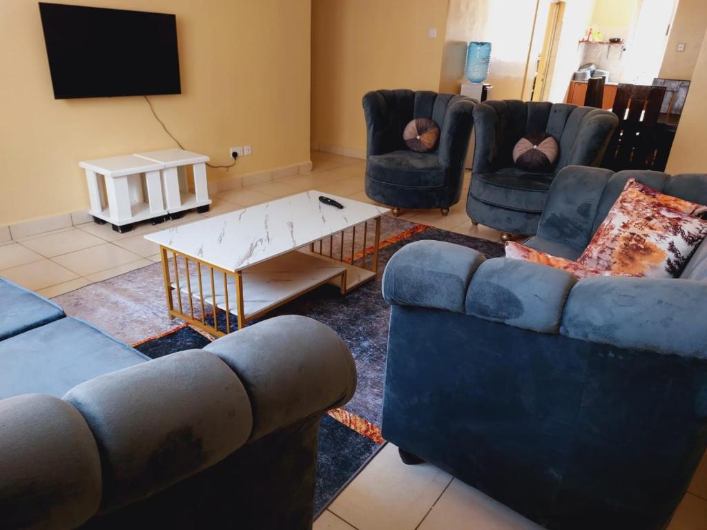 a living room with couches and a coffee table at Solomon's Palace - Nairobi in Nairobi