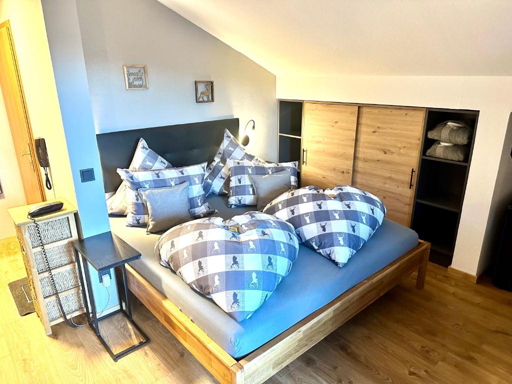 1 dormitorio con 1 cama con almohadas azules y blancas en Ferienappartment Zürker, en Garmisch-Partenkirchen
