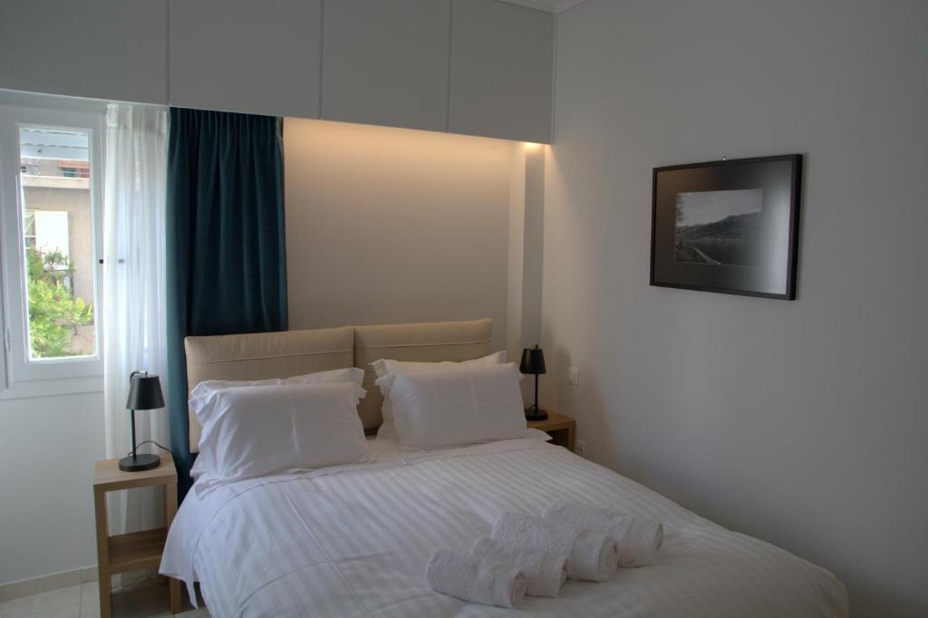 Un dormitorio con una cama con sábanas y almohadas blancas. en Rooster Ioannina, en Ioannina
