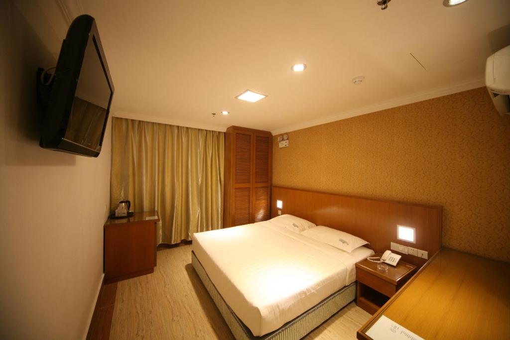 pokój hotelowy z łóżkiem i telewizorem z płaskim ekranem w obiekcie Cardogan Hotel w Kuala Lumpur