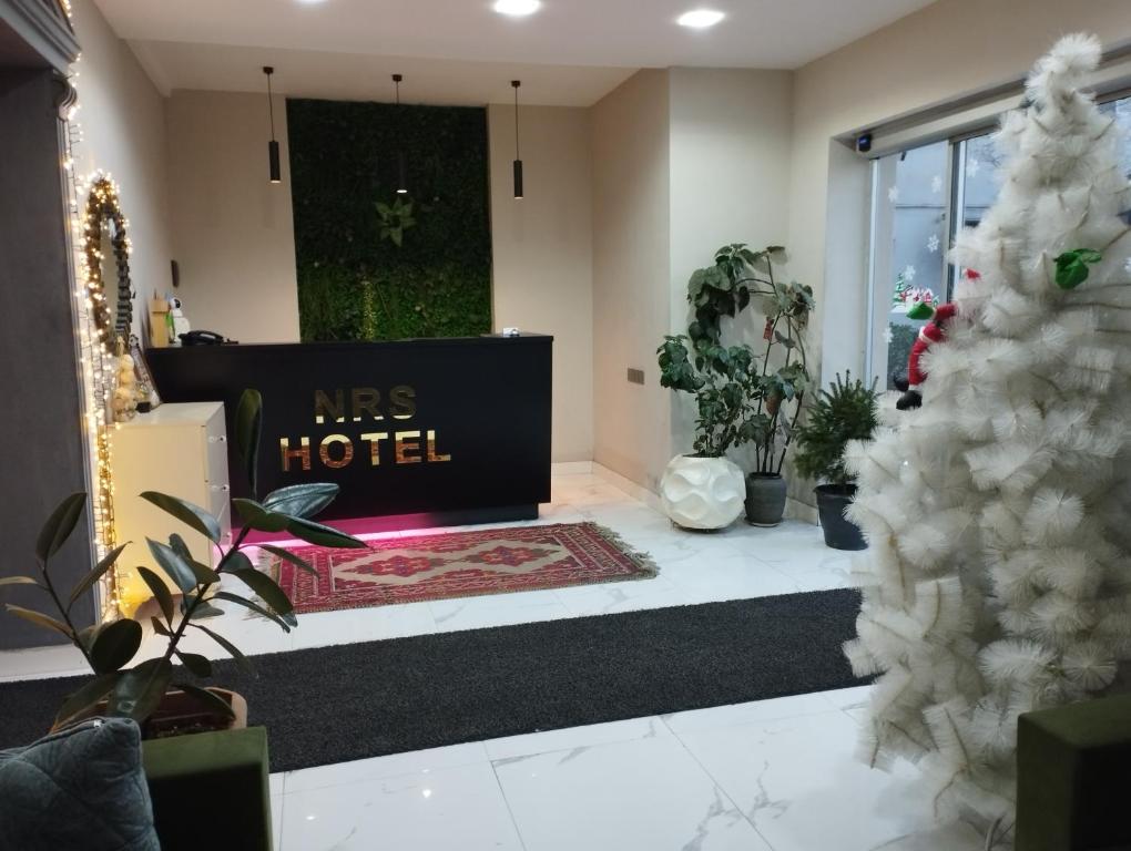 a lobby with a msg hotel sign and plants at NRS Hotel in Baku