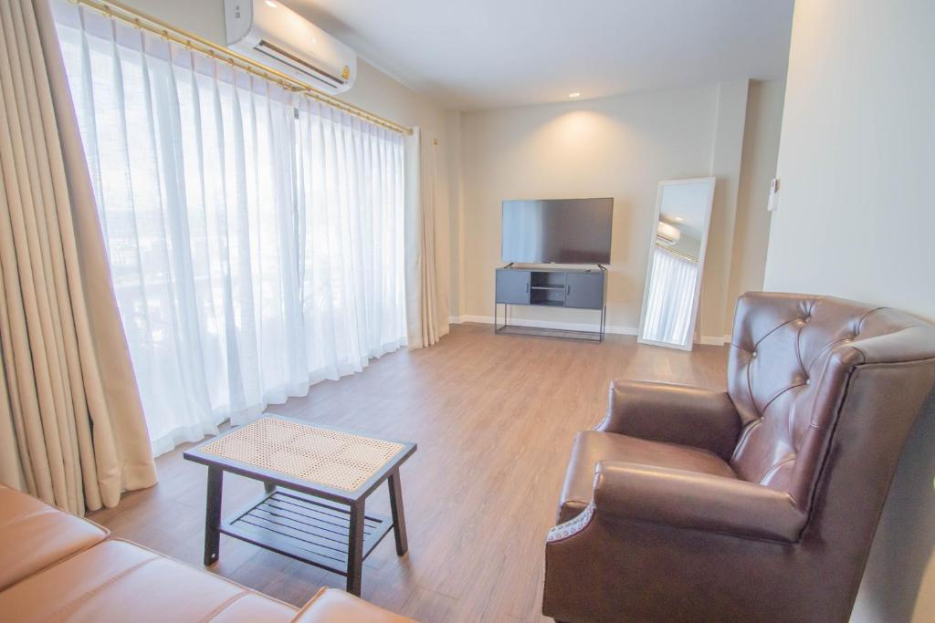 ein Wohnzimmer mit einem Sofa und einem TV in der Unterkunft RoomQuest The Peak Patong Hill in Patong Beach