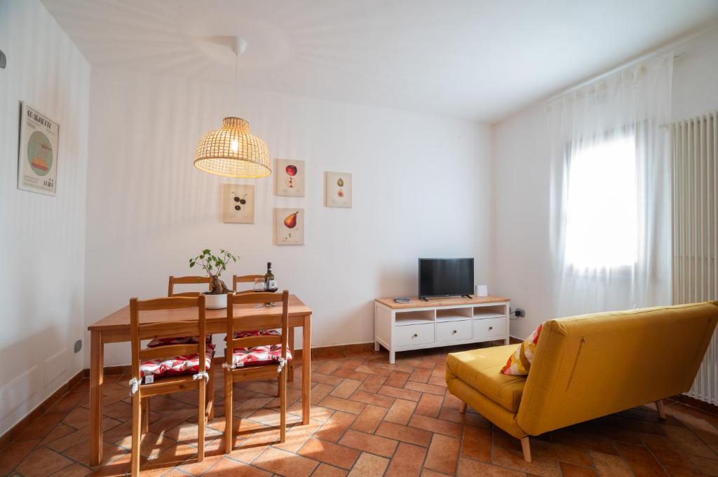 ein Wohnzimmer mit einem Tisch und einem gelben Sofa in der Unterkunft Appartamento Freschi in San Miniato
