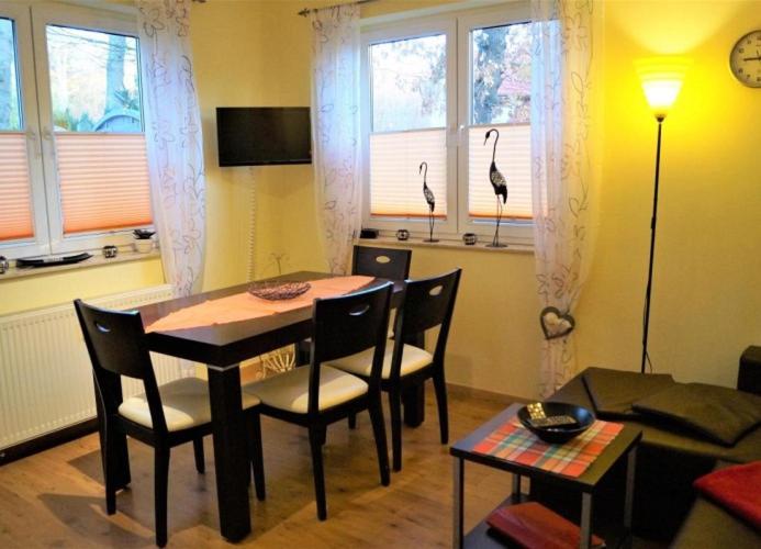un soggiorno con tavolo da pranzo e sedie di Gemütliche Fewo in Strandnähe mit E-Grill, Haustiere erlaubt a Graal-Müritz