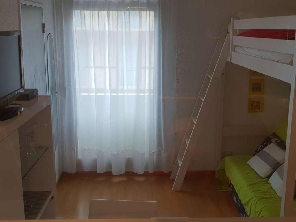 une chambre avec un lit superposé et une fenêtre dans l'établissement Appartement T2 à Cauterets, proche centre, parking et box inclus, idéal pour 5 personnes - FR-1-234-237, à Cauterets