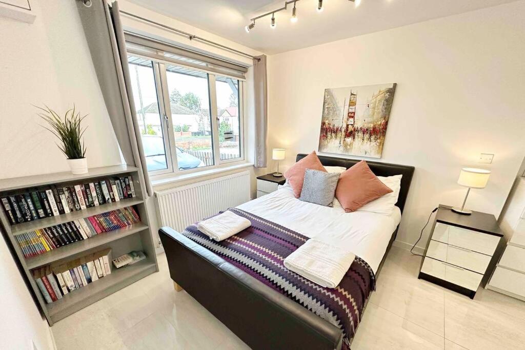 1 dormitorio con cama y estante para libros en Walnut Flats-F1, Luxurious 2-Bedroom with Ensuite - Parking, Netflix, WIFI - Close to Oxford, Bicester & Blenheim Palace, en Kidlington