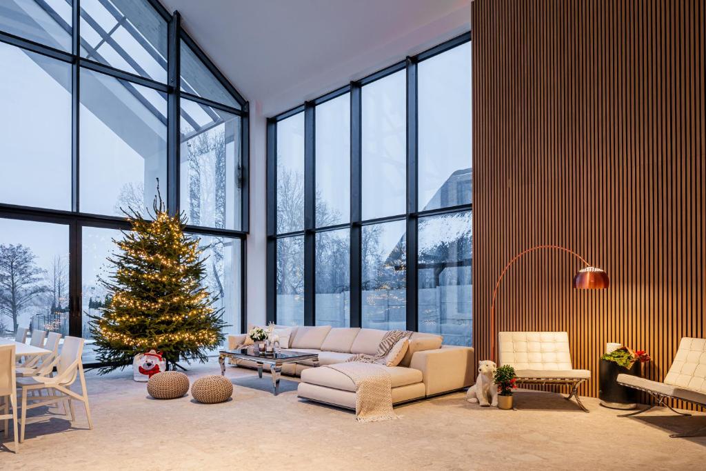 een woonkamer met een kerstboom en een bank bij Boskata Spa & Wellness Resort Ślesin in Mikorzyn