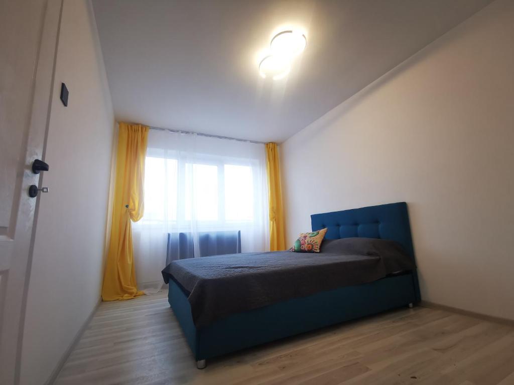een slaapkamer met een blauw bed en een raam bij Nikos Residence in Roman