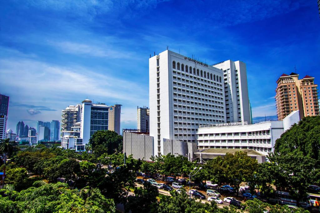 eine Skyline der Stadt mit hohen Gebäuden und Autos in der Unterkunft Grand Sahid Jaya CBD in Jakarta