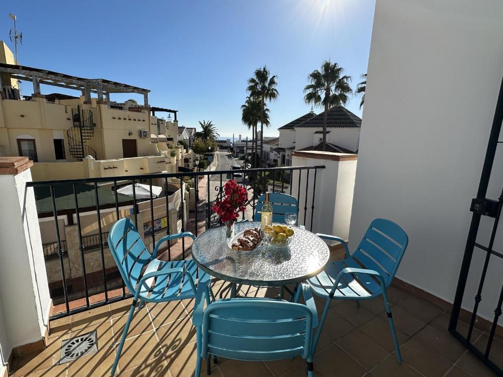 een tafel en stoelen op een balkon met uitzicht bij Nerja Paradise Rentals - Apt Chimenea A1E in Nerja