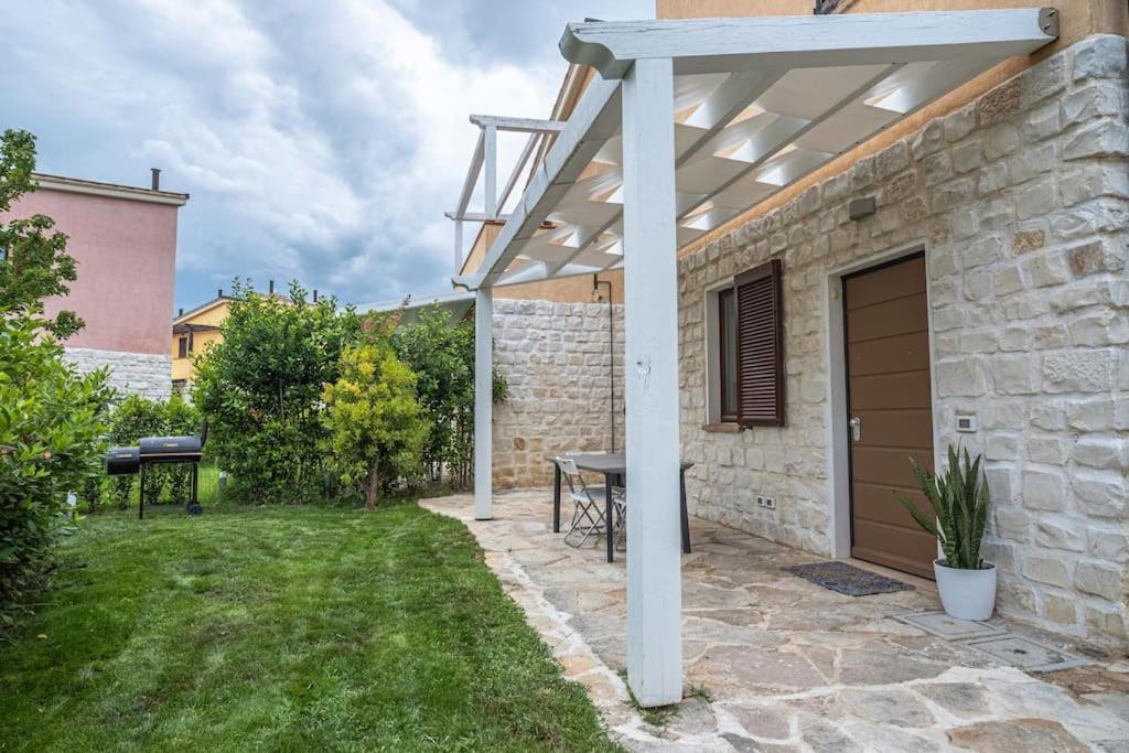 un patio con una pérgola de madera y una mesa en The Pellegrino Spot, en Numana
