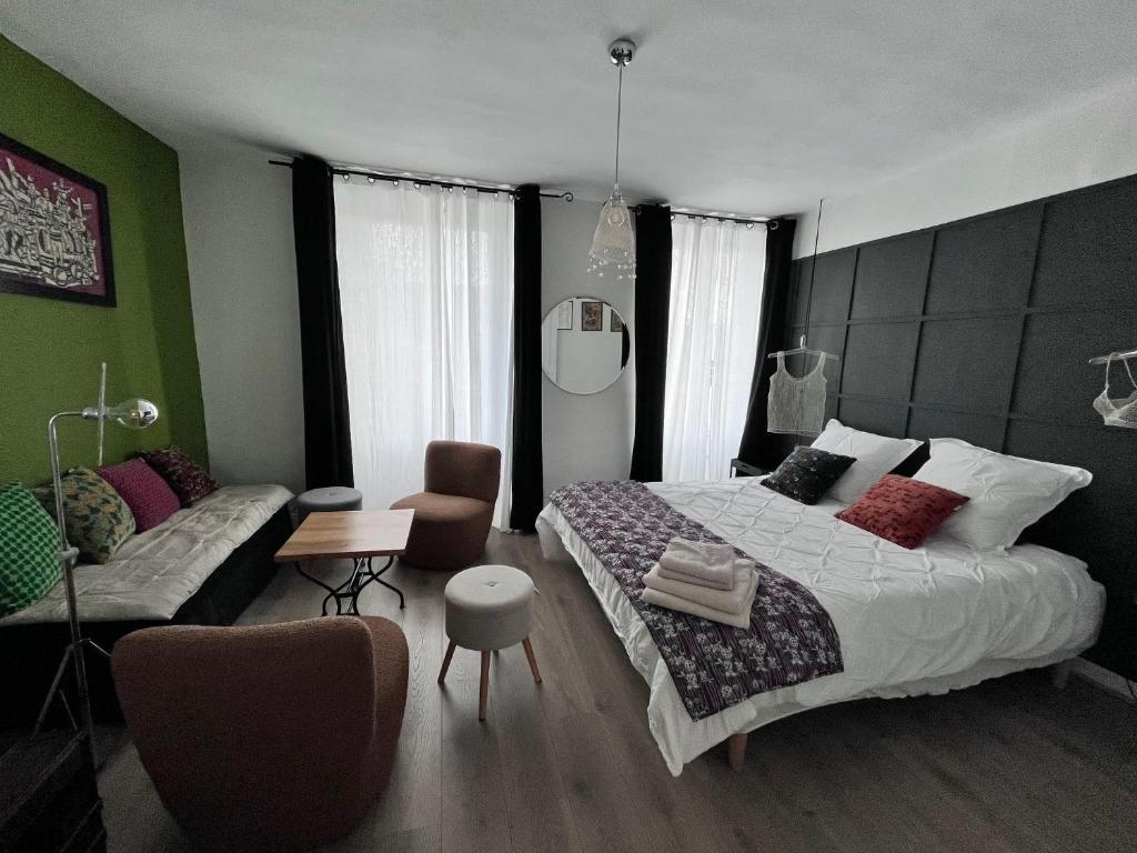 une chambre avec un lit et un canapé dans l'établissement Appartement Bulles de Lumière, à Épernay