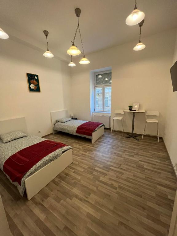 een slaapkamer met 2 bedden en een tafel en stoelen bij Goldensun Apartment in Boedapest