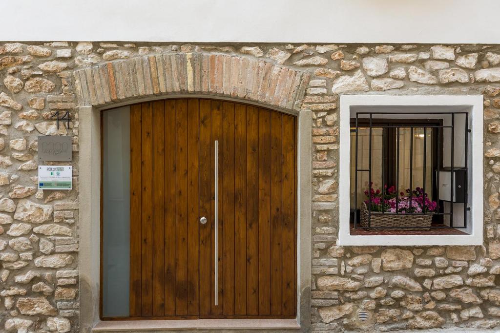 un edificio de piedra con una puerta de madera y una ventana en Casa Santiago casa rural, en Tivenys