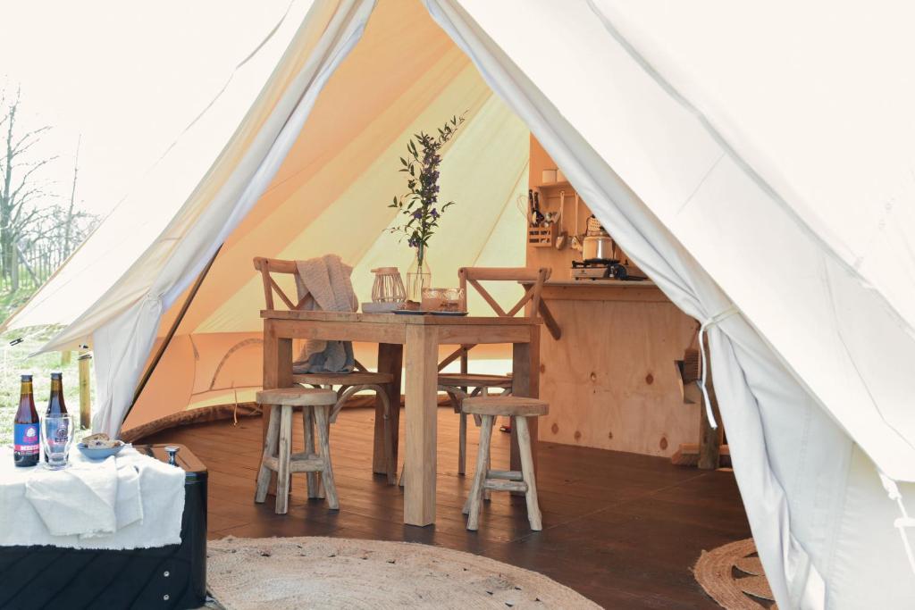 een tent met een tafel en stoelen erin bij Smuk Grutte Bell Tent in Echtenerbrug