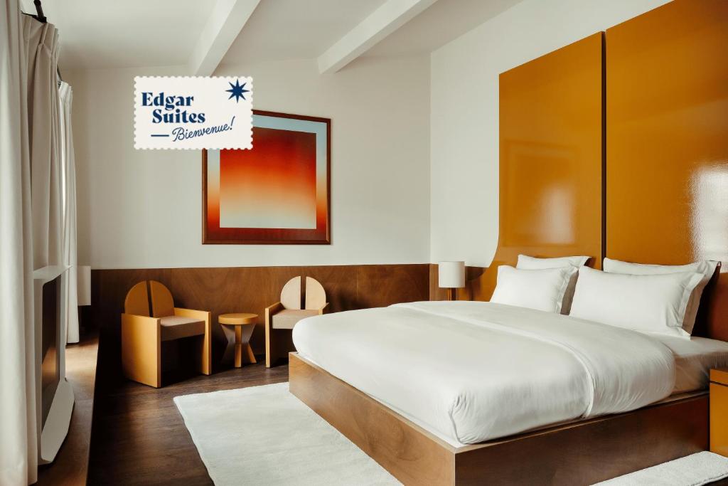 1 dormitorio con 1 cama grande y 1 mesa en Edgar Suites - Bouchardon en París