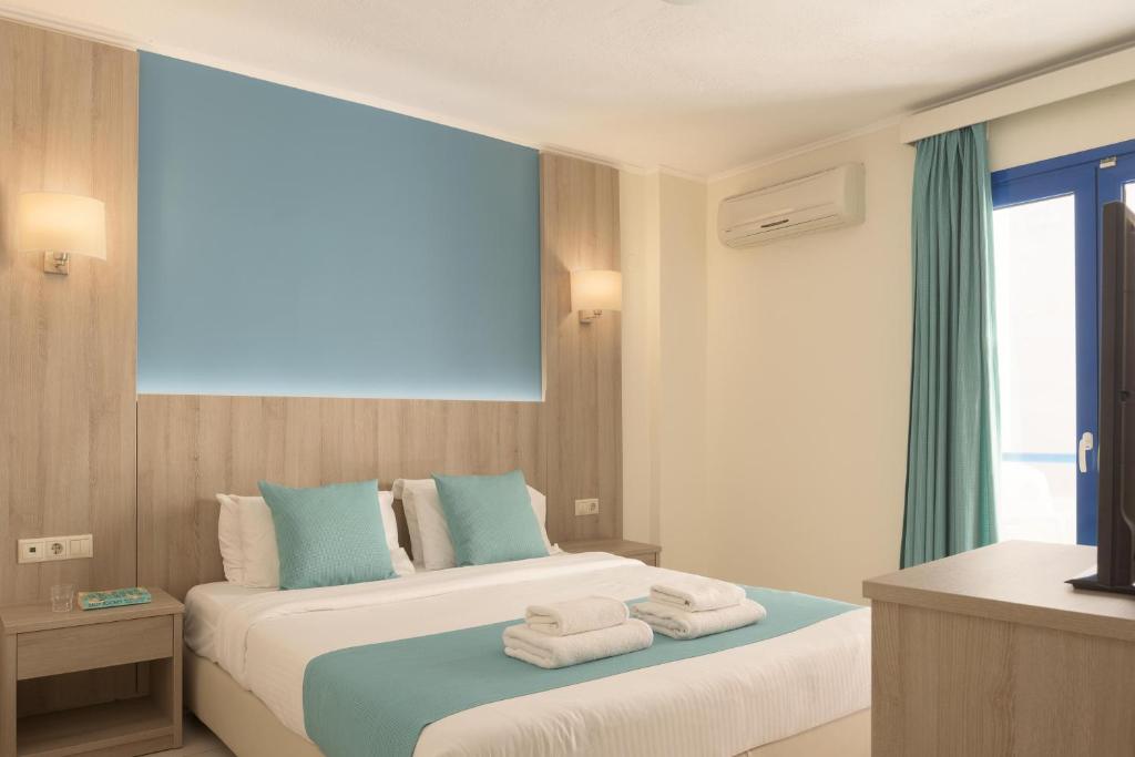 um quarto de hotel com duas camas com toalhas em Central Hersonissos Hotel em Hersonissos