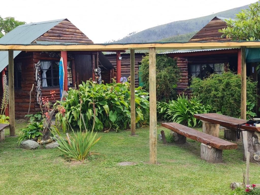 a wooden cabin with a bench in front of it at Tsitsikamma Wolf Sanctuary ECO Cabins & Teepees in Stormsriviermond