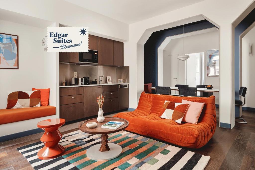 - un salon avec un canapé orange et une table dans l'établissement Edgar Suites Lille - Faidherbe, à Lille