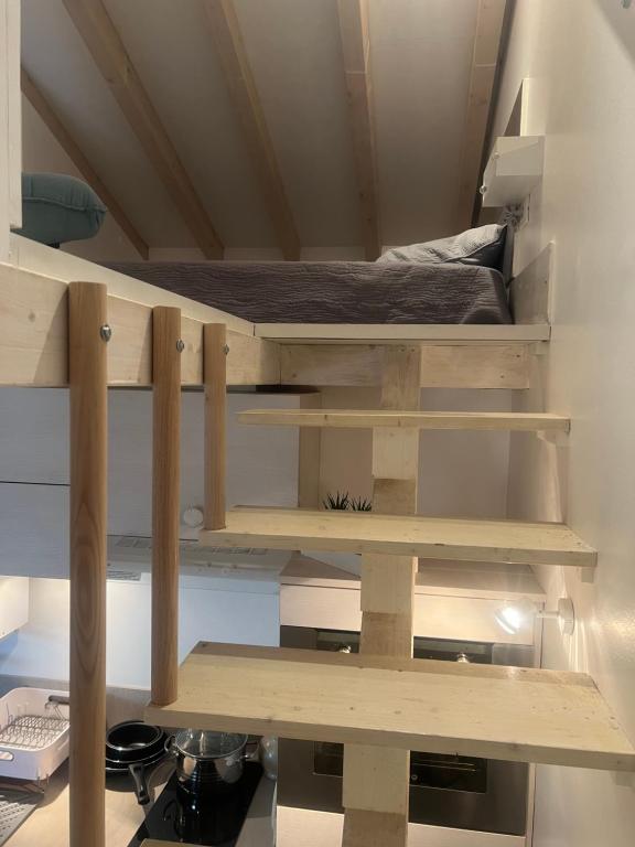 Zimmer mit Holzregalen und einem Bett in der Unterkunft Mimosas Cottage 2 Pièces eze bord de mer in Èze