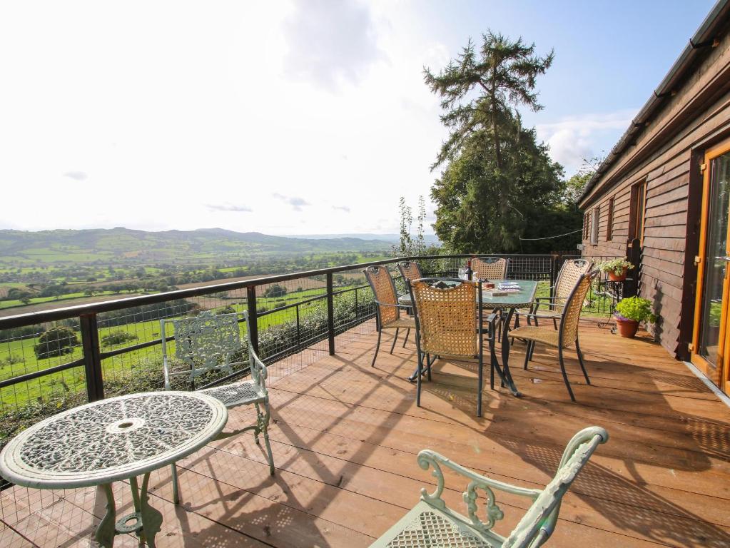 a patio with tables and chairs on a balcony at Dragonfly Lodge in Shrewsbury