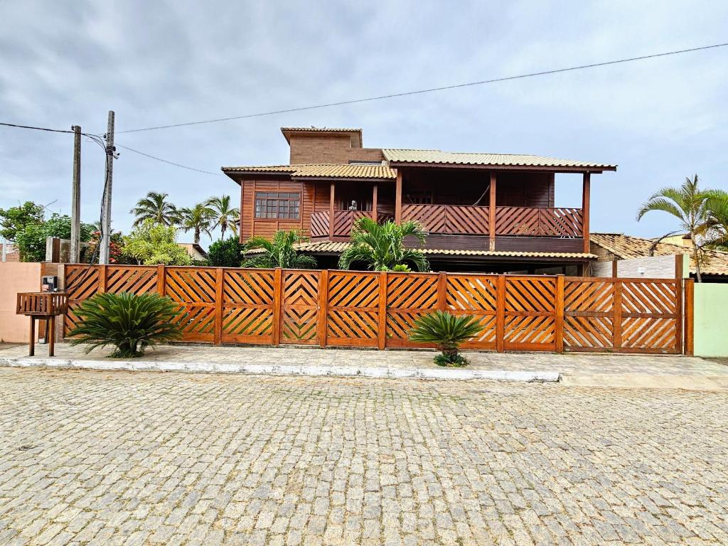 una casa con una valla de madera delante de ella en Casa em Grussai 6 quartos e piscina Sâo Joâo da Barrra-RJ, en São João da Barra