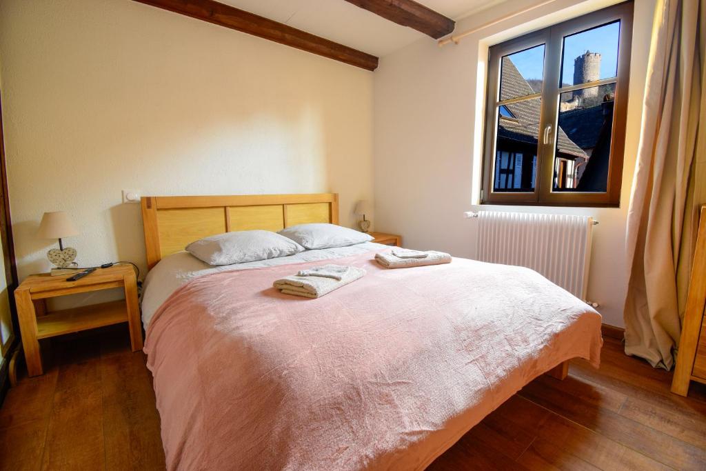 a bedroom with a large bed with two towels on it at Duplex en ville vue château - Studio - Parking in Kaysersberg