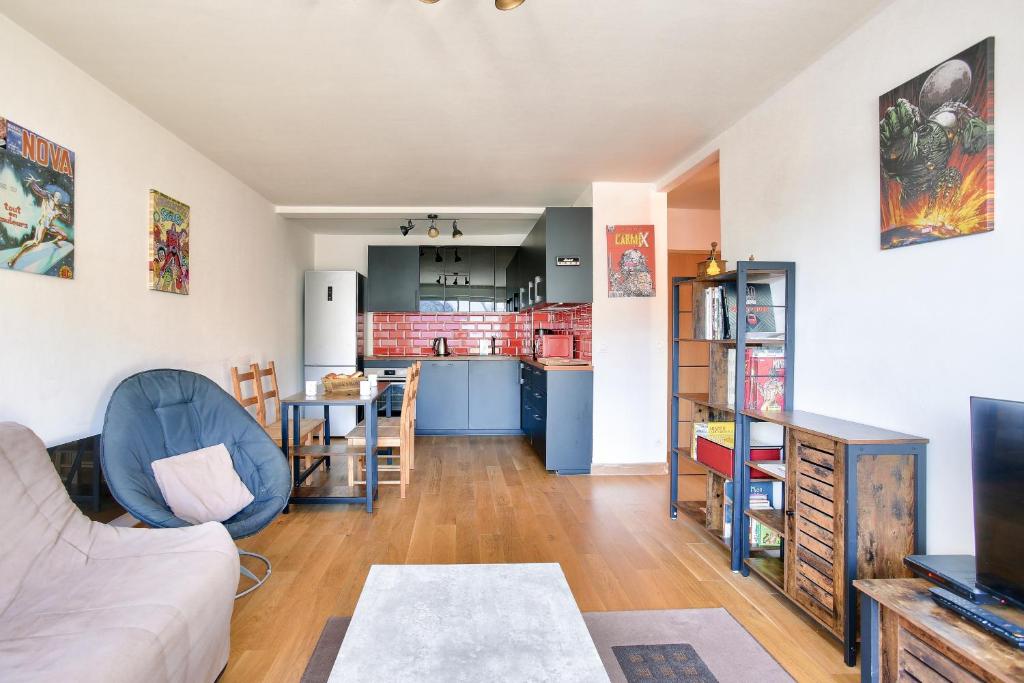 a living room with a couch and a kitchen at Vacances au pied de la plage du Val-André in Le Val-André