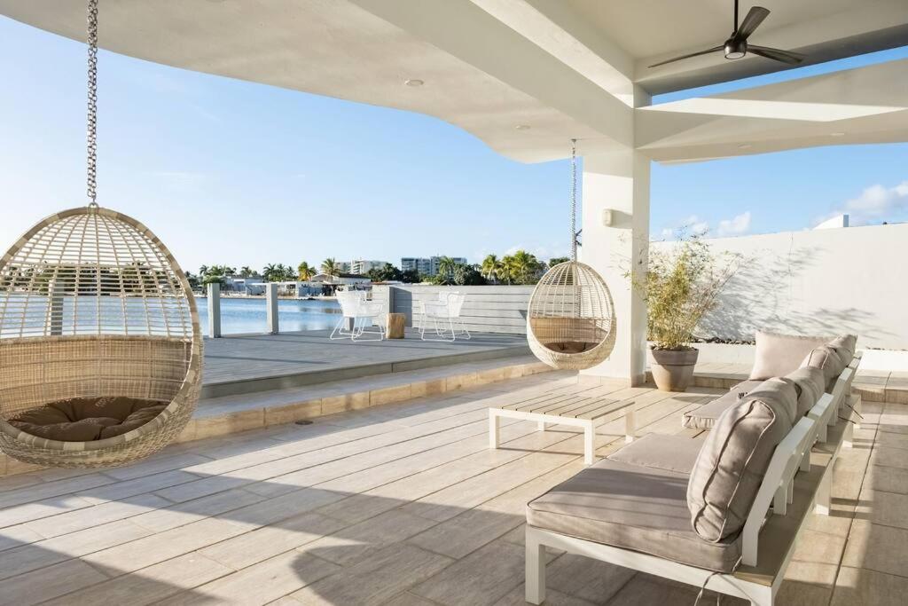 eine Veranda mit zwei Schaukeln und einer Hängematte in der Unterkunft Vistamar Villa 5BDR Private Waterfront Home Pool 