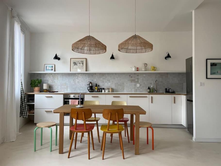 une cuisine avec une table et des chaises en bois dans l'établissement 8AUB - Superbe cosy appartement à deux pas du vieux port, à Marseille