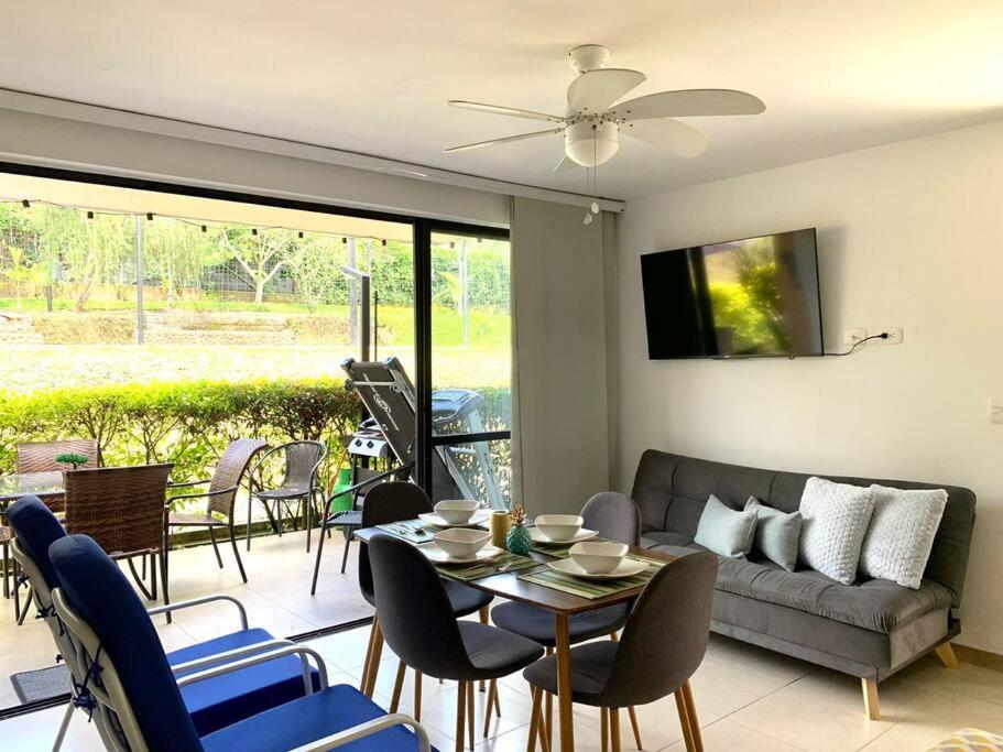 a living room with a couch and a table and chairs at Apartamento Eje Cafetero Parque del Café in La Tebaida