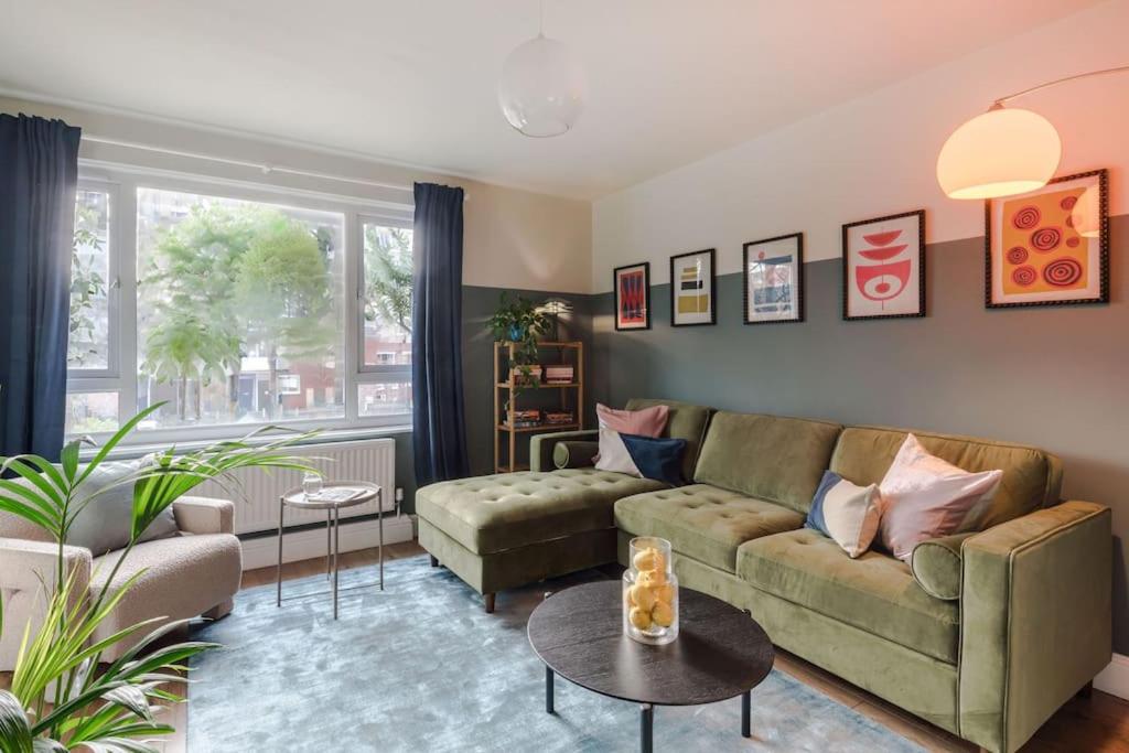 a living room with a couch and a table at The Clissold, Two Bedroom Apartment N5 in London