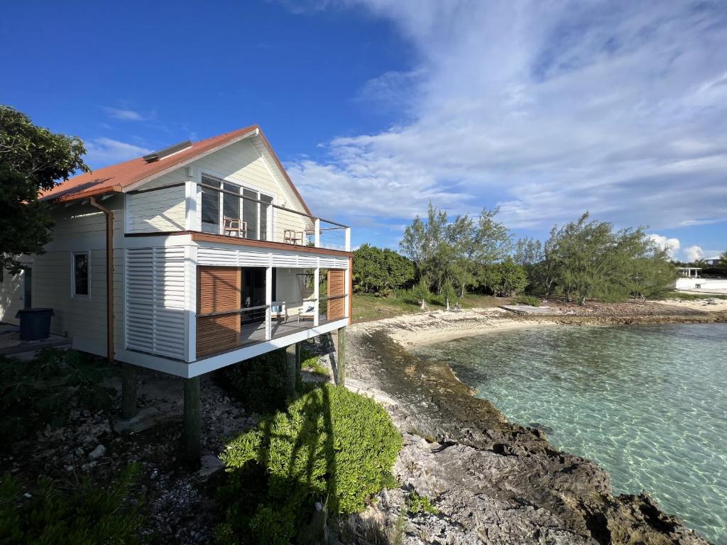 a house on the shore of a body of water at Touch of Class Cottage home in Savannah Sound