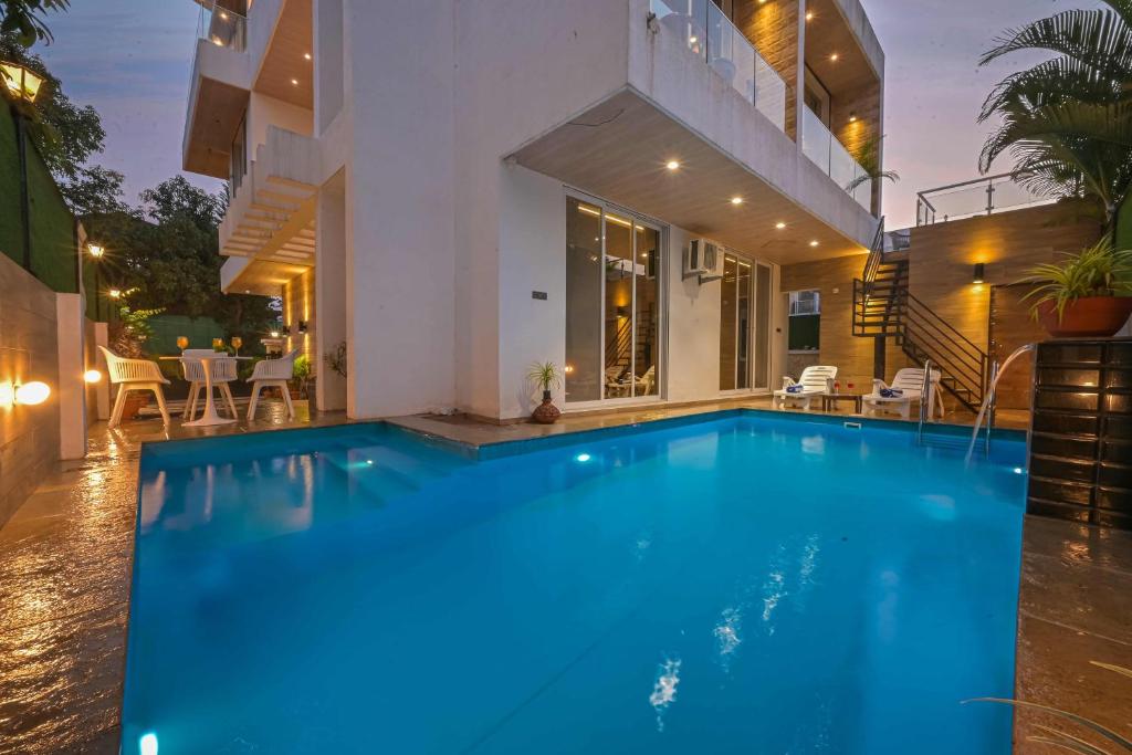 a swimming pool in front of a house at Elegant Villa By Tropicana Stays in Lonavala