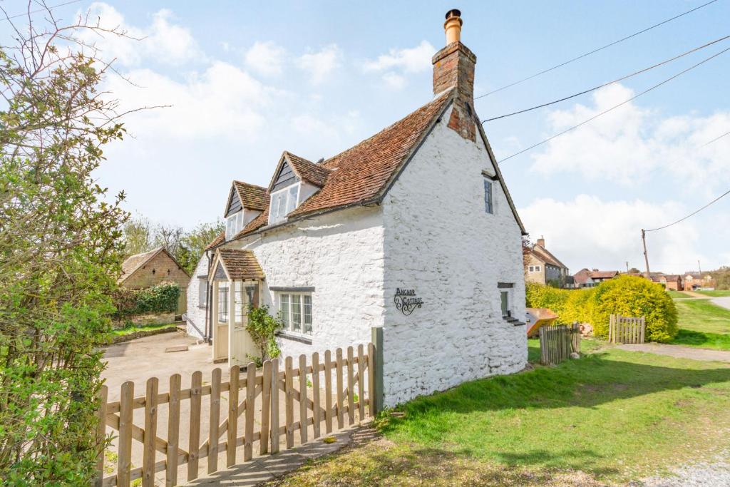 a white cottage with a wooden fence at Anchor Gate Cottage Near Le Manoir A'QuatSaisons By Aryas Properties - Oxfordshire in Stadhampton