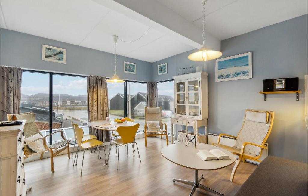 una sala de estar con mesas y sillas y una gran ventana en Fan Bad, Lejl, 50 en Fanø