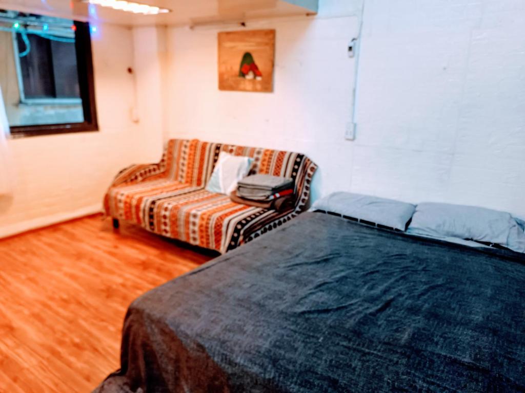 a bedroom with a couch and a bed and a chair at Private Homestay 402 Lily's house 2 beds in city center in Ho Chi Minh City